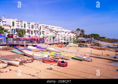Barcos de pesca tirados en la playa frente al paseo marítimo en Cabanas Algarve Este Portugal Foto de stock