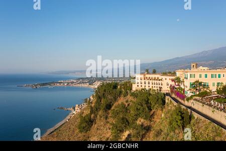 Taormina, Messina, Sicilia, Italia. Vista desde la Piazza IX Aprile sobre la Bahía de Naxos hasta la distante Giardini-Naxos, el hotel San Domenico Palace.