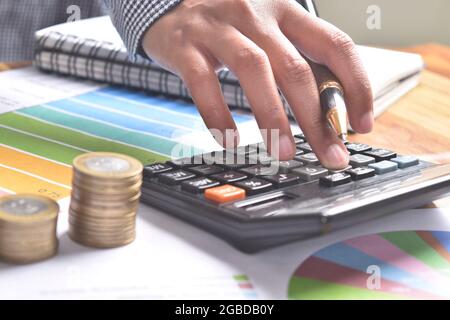 Cálculo manual de impuestos en la calculadora en la oficina Foto de stock