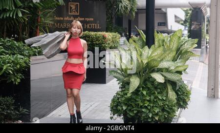 Modelo femenino vistiendo una blusa roja, larga falda negra, un pequeño  bolso y accesorios alrededor de su cuello Fotografía de stock - Alamy