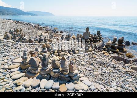 Pirámides de piedras de mar en la orilla del mar. Entrada al mar.