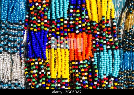 Collares tribales africanos en colores vibrantes. Primer plano de intrincado trabajo de cuentas para la venta en un mercado callejero en Sudáfrica. Foto de stock