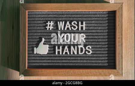 Lave sus manos hashtag mensaje en fieltro valla en la tienda de negocios buena higiene de manos para la prevención del coronavirus. Sentía signo de las redes sociales Foto de stock