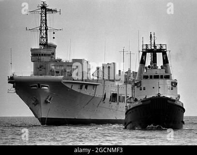 AJAXNETPHOTO. 24TH DE ABRIL DE 1974. PORTSMOUTH, INGLATERRA. - SCRAPYARD BOUND - LA CLASE COLOSSUS DE PORTAAVIONES DE LA FLOTA LIGERA HMS TRIUNFO SIENDO REMOLCADO FUERA DE LA BASE NAVAL AL PATIO DE CHATARRA. FOTO: JONATHAN EASTLAND/AJAX. REF:7419 28 67 Foto de stock