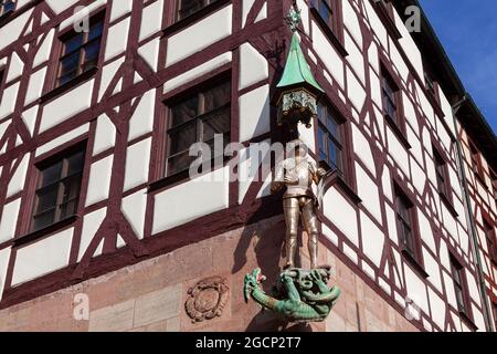 Estatua de San Jorge en armadura en la esquina de la casa . Antigua casa tradicional en Nuremberg . Escultura de caballero con dragón Foto de stock
