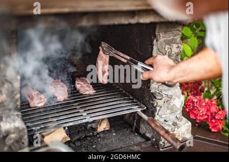 Hombre Que Cocina La Carne En Parrilla De La Barbacoa En El Partido Del  Verano Foto de archivo - Imagen de hombres, concepto: 89095444