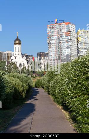San Petersburgo, Rusia-circa Jun, 2021: Nueva iglesia está en el distrito de Kudrovo. El parque Okkervil con nuevos edificios de viviendas está en plantas verdes. Lo es Foto de stock