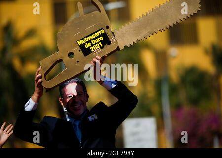 Un activista de Greenpeace lleva una máscara que representa el rostro de Arthur Lira, Presidente de Cámara Baja de Brasil, quien tiene una falsa motosierra durante una protesta contra el 'desmantelamiento