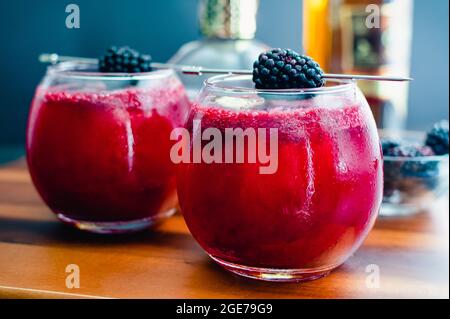 Cócteles de ron y Blackberry servidos en Globe Glasses: Bebidas hechas con ron oscuro y jarabe de blackberry y servidas sobre hielo Foto de stock