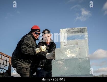 Dos talladores de hielo profesionales esculpiendo bloque de hielo Foto de stock