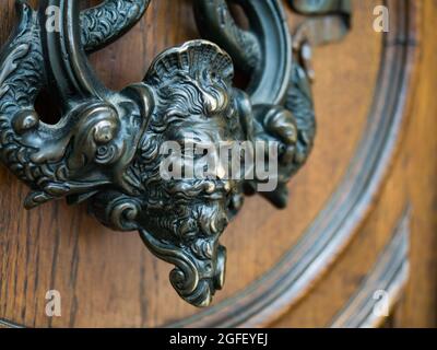 Antiguo tejedor de metal en la puerta de madera de una de las casas de los inquilinos en Viena, Austria Foto de stock
