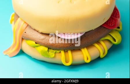 Pastel de hamburguesa, Madeira y pastel de chocolate con capas de esponja,  relleno de helado cubierto con hielo suave y decoraciones de azúcar  comestible, pastel en forma de b Fotografía de stock -