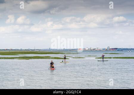 Paddle boarders en Southampton Water/ en Solent, Calshot, Hampshire, Inglaterra, Reino Unido Foto de stock