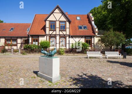 Rostock-Warnemuende, histórica casa de pescadores en Alexandrinenstrasse, escultura Drei Klaashahns Foto de stock