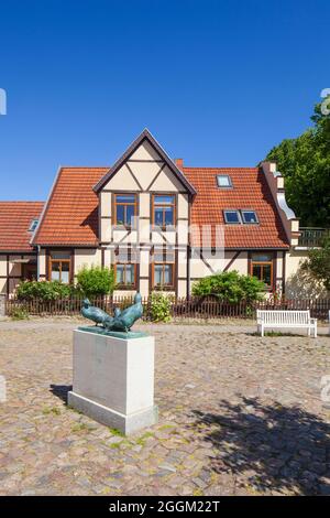 Rostock-Warnemuende, histórica casa de pescadores en Alexandrinenstrasse, escultura Drei Klaashahns Foto de stock