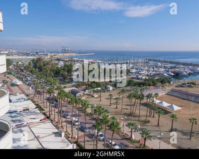 Vista aérea superior con vistas al paseo marítimo de Finikoudes con palmeras, yates en el puerto y cancha de voleibol en la playa mediterránea en un día soleado