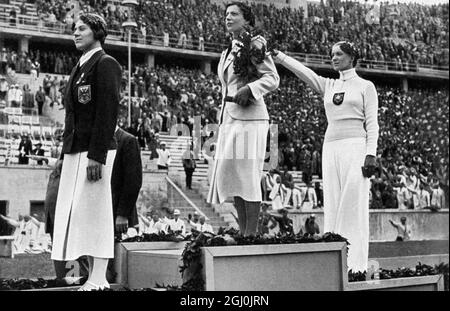 Olimpiadas de 1936, Berlín - Los ganadores de la competición de esgrima son premiados en el estadio olímpico (de izquierda a izquierda) Ellen S. Preis-Muller (Austria 3rd), Ilona Elek-Schacherer (Hungría 1st), y Helene Mayer (Alemania 2nd). ©Topfoto Foto de stock