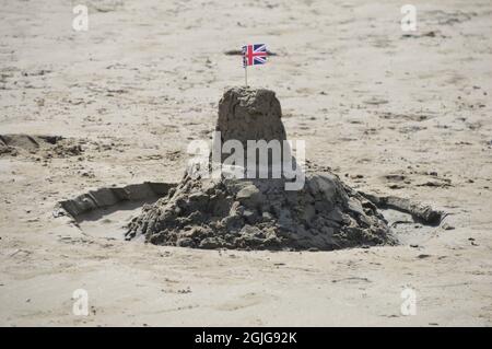 Sandcastle con bandera de Union Jack en la playa de Black Rock Sands en Snowdonia Foto de stock