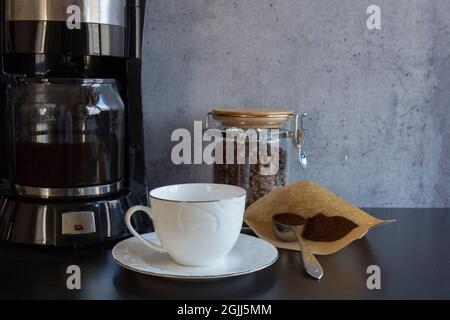 máquina de café, una taza, un tarro lleno de granos de café y una cuchara de  café turco Fotografía de stock - Alamy