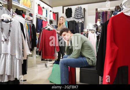 Hombre a su novia mientras ella ropa la tienda moderna Fotografía de stock - Alamy