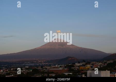 vista del volcán popocatepetl, con una salida de humo al atardecer