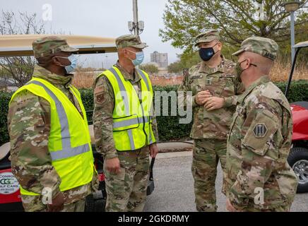 Jefe de la Fuerza Aérea de los Estados Unidos, Sgt. Robert Ellis, Superintendente del Escuadrón de Operaciones Médicas Expedicionarias (EMOS) de 64th (extremo izquierdo), y el Coronel de la Fuerza Aérea de los Estados Unidos Danny Wong, Comandante de la EMOS de 64th (izquierda), hablan con el General de División del Ejército de los Estados Unidos Pablo Estrada, Comandante General de la Fuerza de Tarea 46 (derecha) y Comando del Ejército de los Estados Unidos. Sr. Jody Arrington, Sargento Mayor del Comando del Grupo de Trabajo 46 (extremo derecho), en el Centro de Vacunación Comunitaria del NRG (CVC) en Houston, 24 de marzo de 2021. Los equipos de comando de la Fuerza de Tarea 46 y 64th EMOS discutieron las operaciones y la distribución de vacunas en la CVC de Houston. Comando Norte, a través de EE.UU Foto de stock