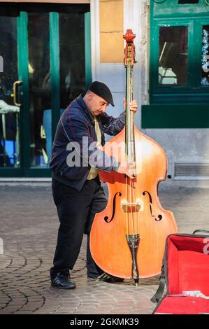Roma, Italia - 01 de enero de 2013: Un músico de la calle toca el contrabajo cerca de Santa Cecilia en la Iglesia Trastevere para consejos y para promover su canción en CD. Foto de stock