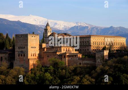 Montañas nevadas y el Palacio de la Alhambra brillan de naranja poco antes de la puesta de sol en Granada, Andalucía, España Foto de stock