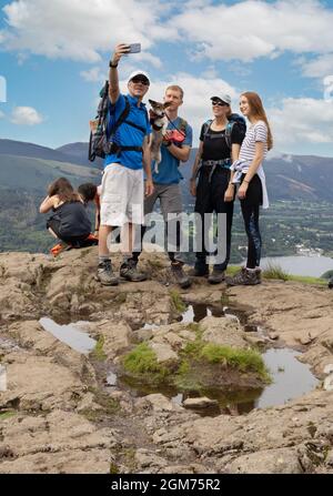 Familia selfie Reino Unido; una familia tomando una foto familiar en Walla Crag cerca de Keswick, en la estatificación en verano, Lake District National Park, Cumbria Reino Unido