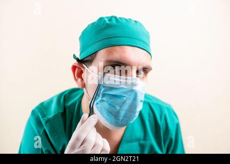 Doctor ENT, usando una máscara y gafas, con un dispositivo en sus manos. Foto de stock