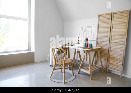 Lugar de trabajo de Tailor con máquina de coser cerca de la pared verde  Fotografía de stock - Alamy