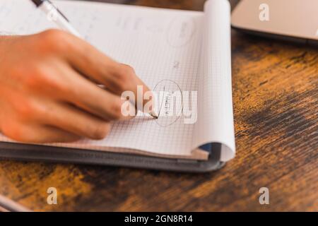 Psicólogo masculino escribiendo en bloc de notas mientras trabaja en la oficina Foto de stock