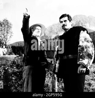 LOS ROLLOS AMARILLOS-ROYCE, de izquierda, el director Anthony Asquith, Omar Sharif, on-set, 1964