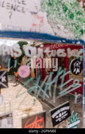 Turista a través de un espejo lleno de graffiti en París, Francia
