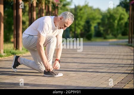 Un hombre de mediana edad en ropa deportiva lazando sus snickers Fotografía  de stock - Alamy