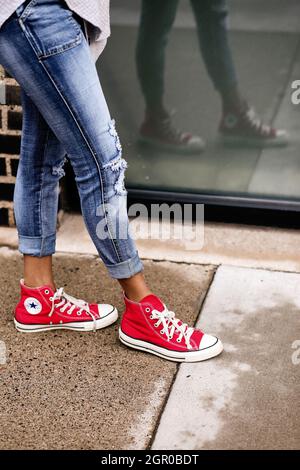 MINNEAPOLIS, ESTADOS UNIDOS - Jul 20, un primer plano de las piernas de una mujer con jeans sneakers rojas Fotografía de stock - Alamy