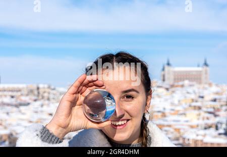 Retrato de una joven sosteniendo el paisaje urbano en la ciudad contra el cielo