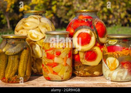 Pickles caseros en latas, comida y bocadillos rústicos, pepinos enlatados, tomates, berenjenas y col