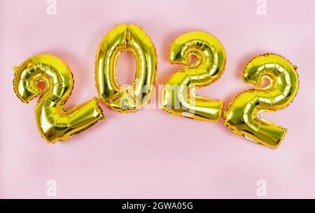 Feliz Año Nuevo 2022. Números 2022 sobre fondo rosa. Espacio de copia.