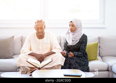 Pareja en el hogar musulmán africano en Ramadán leyendo el Corán holly islam libro Foto de stock