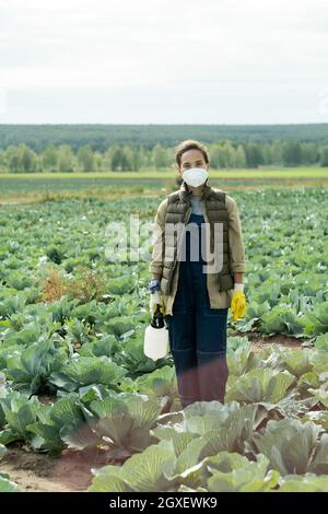 Joven mujer campesina en ropa de trabajo de protección de pie en campo de  repollo Fotografía de stock - Alamy