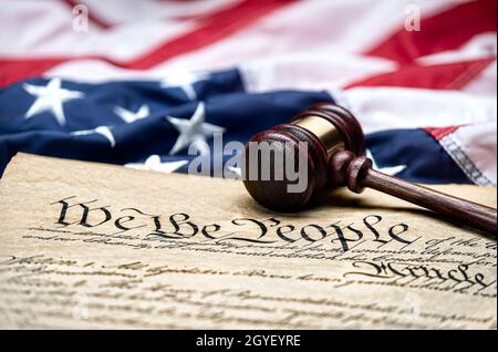 La bandera estadounidense se alzó alrededor del bloque de gavel de un juez y de la Constitución de los Estados Unidos para su uso como símbolo de leyes, libertad y separación del gobierno Foto de stock