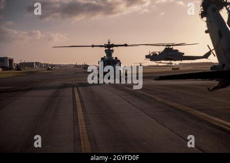 Un helicóptero Venom UH-1Y del Cuerpo de Marines de EE.UU., frente, Y un helicóptero AH-1Z Viper, de regreso, asignado al Escuadrón de Helicópteros de Ataque Ligero Marino (HMLA) 169, 1st Marine Aircraft Wing, (en despliegue a Okinawa como parte del programa de despliegue de la unidad) espera repostar en la Estación Aérea del Cuerpo de Marina Futenma, Okinawa, Japón, 29 de septiembre de 2021. HMLA-169 realizó un simulacro de coordinación y reconocimiento de huelgas para aumentar la competencia y la letalidad en todo el escuadrón. (EE.UU Marine Corps foto por Lance Cpl. Justin J. Marty)