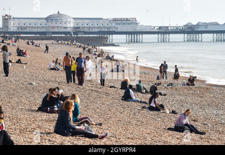 Brighton Reino Unido 9th Octubre 2021 - La playa de Brighton está ocupada mientras los visitantes disfrutan de un día soleado caliente con algunas partes del Sur Oriente previsión para alcanzar más de 20 grados centígrados: Crédito Simon Dack / Alamy Live News