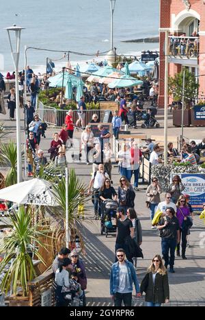 Brighton UK 9th Octubre 2021 - El paseo marítimo de Brighton está ocupado mientras los visitantes disfrutan de un día soleado caliente con algunas partes del Sur Oriente previsión para alcanzar más de 20 grados centígrados: Crédito Simon Dack / Alamy Live News