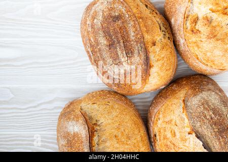 El pan artesanal de trigo se encuentra en la superficie de madera, el fondo, la vista superior.