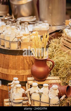 Estilo de vida agrícola, botellas con leche fresca, orejas de cereales en jarra de arcilla, productos orgánicos, concepto de alimentos saludables Foto de stock