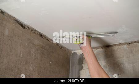 joven hombre utilizando espátula y enlucido de pared con blanco Fresco  refinamiento masilla. de cerca. reparar trabajo de hogar. vacío sitio para  texto. lado vista. 26223984 Foto de stock en Vecteezy