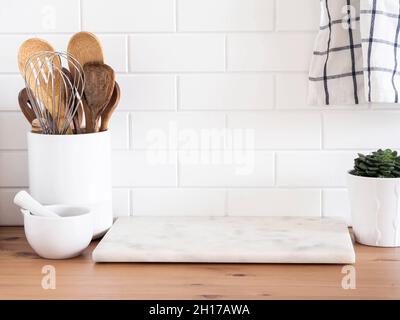 https://l450v.alamy.com/450ves/2h17awa/elegante-fondo-de-cocina-blanco-con-utensilios-de-cocina-y-hogar-verde-de-pie-sobre-encimera-de-madera-cerca-de-azulejos-de-pared-blanca-espacio-de-copia-para-texto-2h17awa.jpg