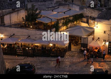 Matera, Italia - 14 de septiembre de 2019: Noche de la vista de la ciudad de Matera, Italia, con las luces de colores resaltando los patios de cafés en la S Foto de stock